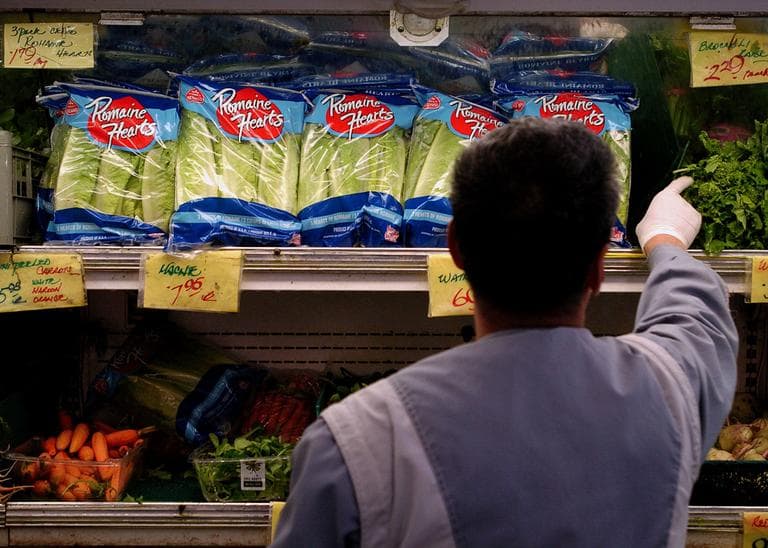 An unidentified produce employee restocks the shelf of bagged lettuce at a grocery store in Berkeley, Calif. (AP)