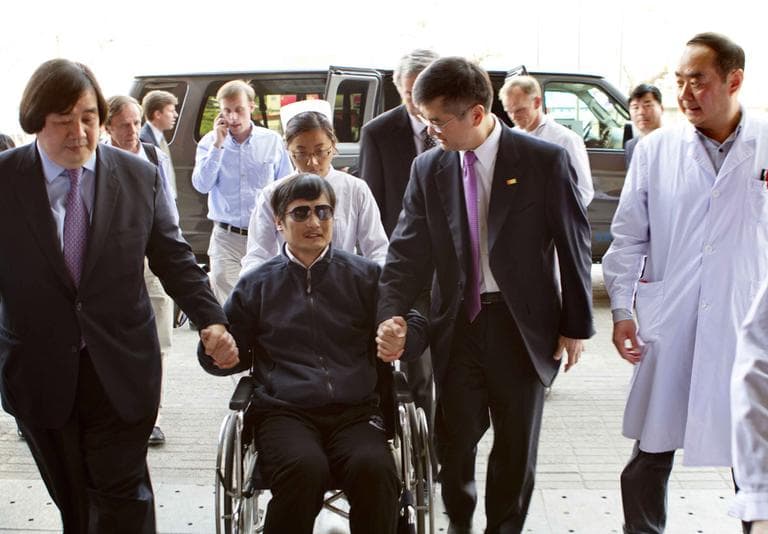 Blind lawyer Chen Guangcheng is wheeled into a hospital by U.S. Ambassador to China Gary Locke, right, and U.S. State Department Legal Advisor Harold Koh at left, in Beijing Wednesday May . (AP /US Embassy Beijing Press Office, HO)