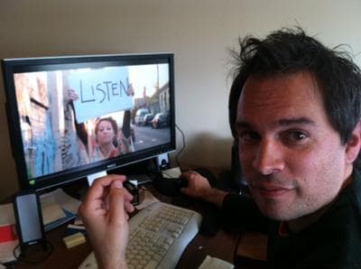 Carly Carioli, editor of the Boston Phoenix, watches Palmer's Kickstarter campaign video. (Andrea Shea/WBUR)
