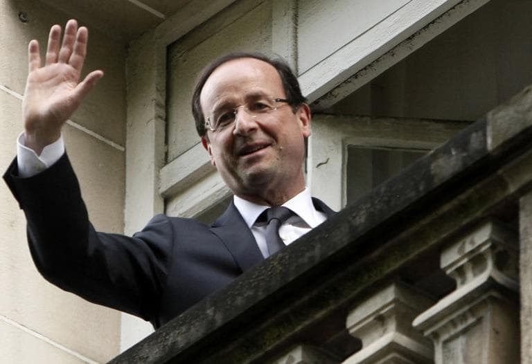 President-elect Francois Hollande waves from the balcony of the Socialist Party headquarters in Paris Monday. (AP)