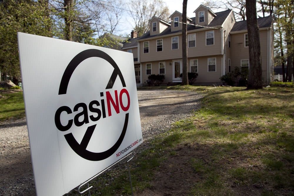 A placard protesting a proposed gambling casino at an unpaved parking lot at Gillette Stadium in Foxborough, Mass. (AP)