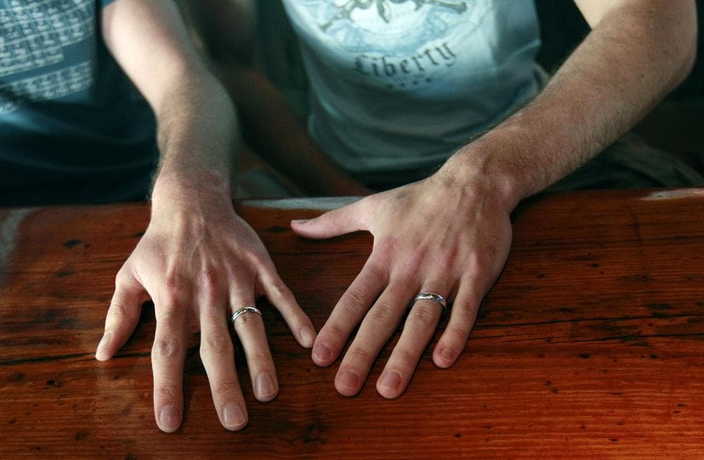 David Peters, right, and Luke Whited, a gay couple who were joined in a civil union in their home state of Illinois, show their rings inside the Bourbon Pub, a gay bar. (AP)