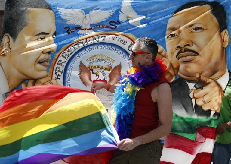 Trenton Garris waves his rainbow flag in front of a banner in support of President Barack Obama who was visiting Seattle on Thursday. (AP Photo/Kevin P. Casey)