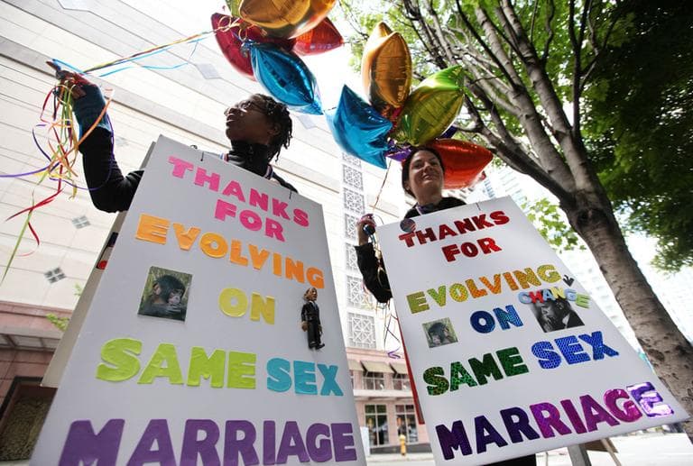 Marriage equality supporters Teri McClain, left, and Mary Beth Brotski stand with signs supporting President Barack Obama outside a fundraising event for the president, Thursday, May 10 in Seattle. (AP)