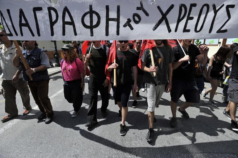 Protesters hold a banner that reads: &#039;&#039;Debt write-off&#039;&#039;, during a May Day protest in the northern Greek port city of Thessaloniki, where more than 8,000 people marched in protests centered on the country&#039;s harsh austerity program. (AP)