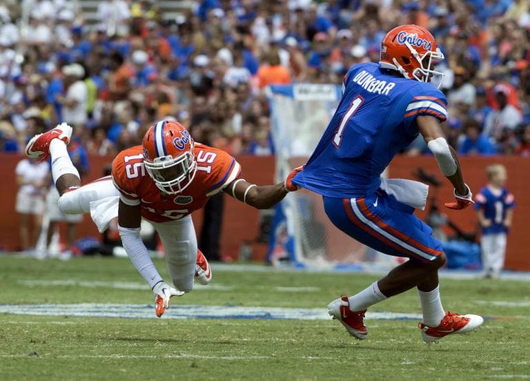 Florida&#039;s linebacker Michael Taylor (15) gets a hand full of jersey as he tries to bring down Quinton Dunbar (1) during the first half of the Orange &amp; Blue football game in Gainesville, Fla. (AP)