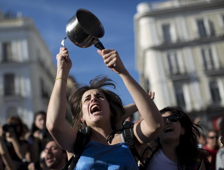 A demonstrator hit a pot during a protest to mark the anniversary of the &quot;Indignados&quot; movement in Sol square, Madrid, Spain, Tuesday May 15, 2012. Spaniards angered by increasingly grim economic prospects and unemployment hitting one out of every four citizens protested in droves in the nation's largest cities, marking the one-year anniversary of a spontaneous movement that inspired similar anti-authority demonstrations across the planet. (AP)