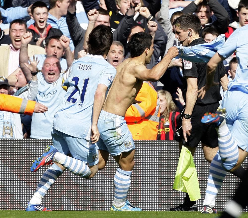 Manchester City's Sergio Aguero, center, celebrates after scoring the game-winning goal against Queens Park Rangers to secure the English Premier League title. (AP)