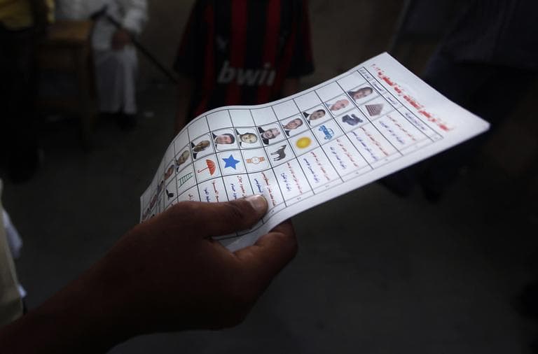 In this Wednesday, May 23, 2012 photo, an Egyptian man holds a ballot paper with names of the 13 presidential candidates inside a polling station, in Alexandria, Egypt. In a wide-open race that will define the nation's future political course, Egyptian voted Thursday on the second day of a landmark presidential election that will produce a successor to longtime authoritarian ruler Hosni Mubarak. (AP)