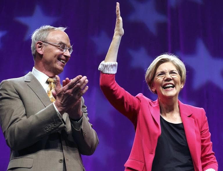 Elizabeth Warren greets the audience accompanied by her husband, Prof. Bruce Mann, after Warren won the delegate's endorsement at the Democratic State Convention in Springfield on Saturday. (AP)