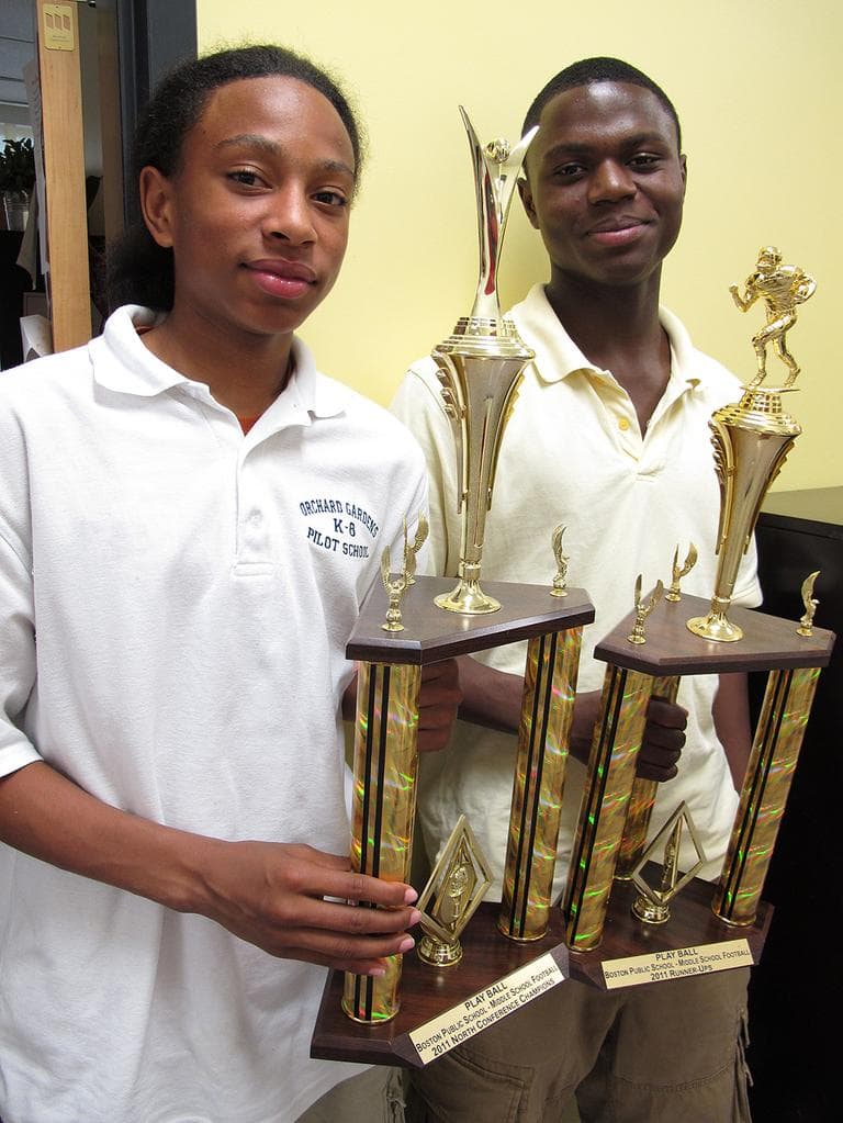 Orchard Garden eighth graders Eric Darron Hall and Tomell Kelley proudly hold a sports trophy they helped win for the school. (Monica Brady-Myerov/WBUR)
