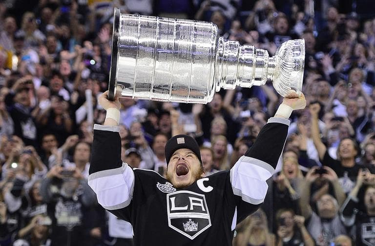 Los Angeles Kings right wing Dustin Brown holds up the Stanley Cup after the Kings beat the New Jersey Devils 6-1 in Game 6. (AP)