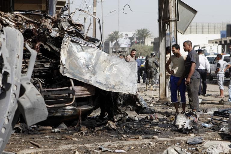 People and security forces inspect the scene of a car bomb attack in the Karrada neighborhood of Baghdad, Iraq, Wednesday, June 13, 2012.  (AP)