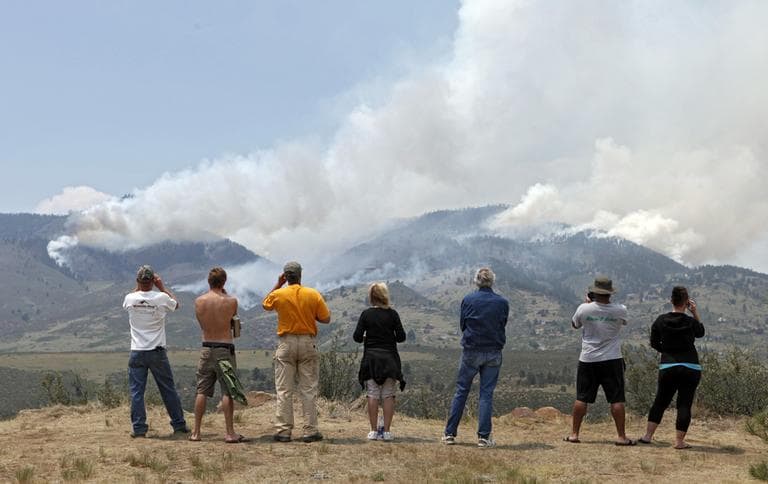 People gather on a hill to watch the High Park wildfire near Fort Collins, Colo., on Monday, June 11, 2012. The wildfire is burning out of control in northern Colorado, while an unchecked blaze choked a small community in southern New Mexico as authorities in both regions battled fires Monday. (AP)