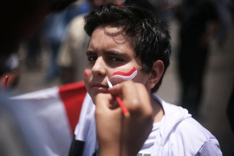 A man paints the colors of the Egyptian flag on a boy&#039;s cheek during a celebration of Mohammed Morsi&#039;s apparent victory in Tahrir Square, Cairo, Egypt. (AP)