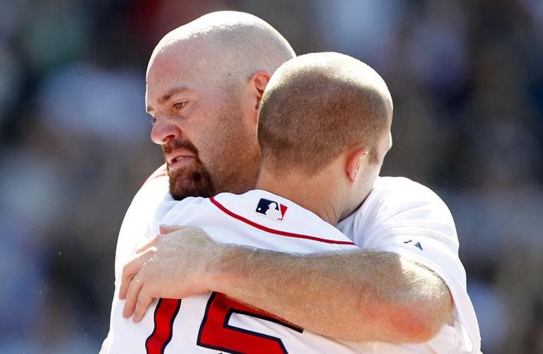 Boston Red Sox's Kevin Youkilis, left, hugs teammate Dustin Pedroia as he comes off the field after hitting a triple Sunday. (AP)