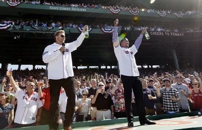 Former Boston Red Sox players Kevin Millar, left, and Pedro Martinez lead the fans in a toast at Fenway Park in Boston, Friday, April 20, 2012, during a celebration of the 100th anniversary of the first regular-season game at the ballpark. (AP)