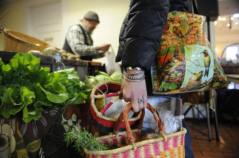 In this photo taken Dec. 9, 2010, Joani Gwilliam, of Plymouth, Mass., holds bags full of herbs and produce while making a stop at one of the many indoor farm stands inside the visitor center at Plimouth Plantation in Plymouth, Mass. (AP)