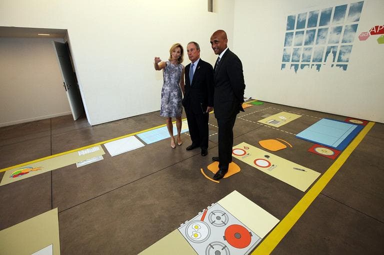 In this photo provided by the New York Mayor's office, Mayor Michael Bloomberg, center, stands with Amanda Burden, left, Department of City Planning Director, and Commissioner Mathew Wambua, Department of Housing Preservation and Development, in the kitchenette area of a full-scale mockup of a 300 square foot apartment. (AP)