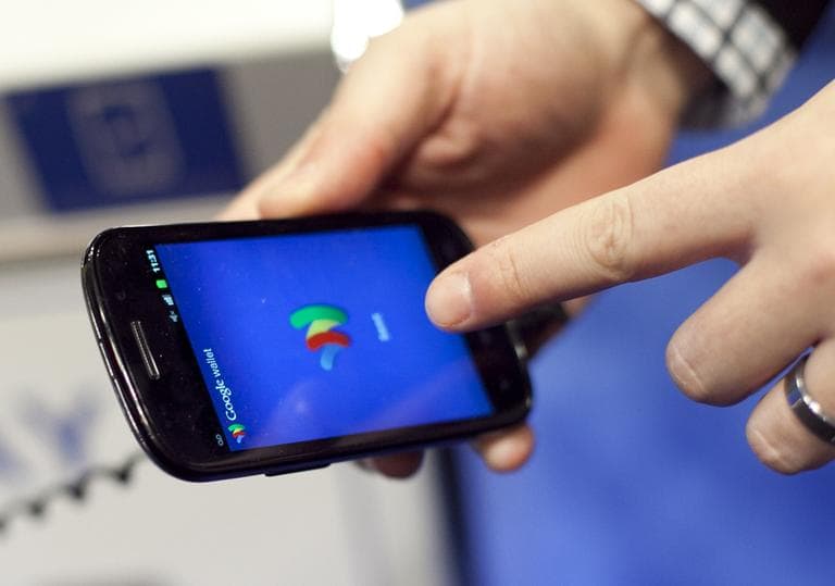 A person tries a smartphone loaded with Google Wallet at the National Retail Federation, Tuesday, Jan. 17, 2012 in New York. (AP)