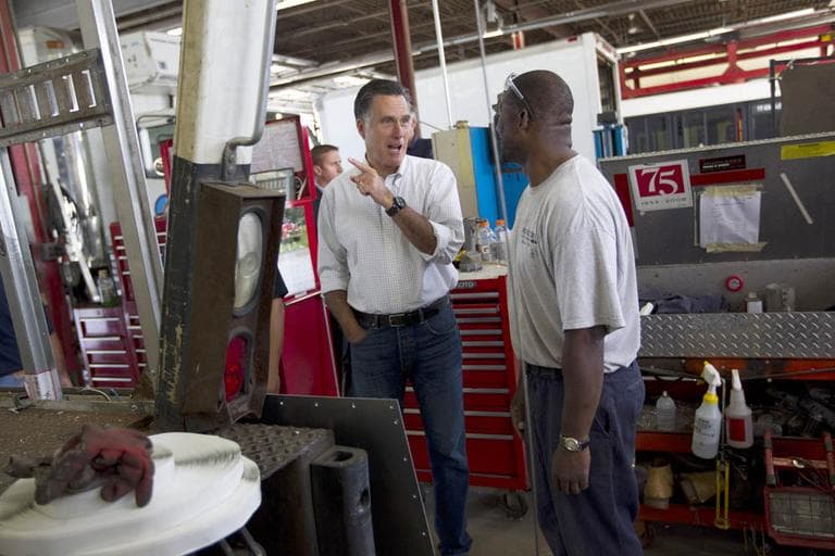Mitt Romney, left, talks with Rodney Hollis, an employee of Middlesex Truck and Coach, during a campaign stop on Thursday in Roxbury. (AP)