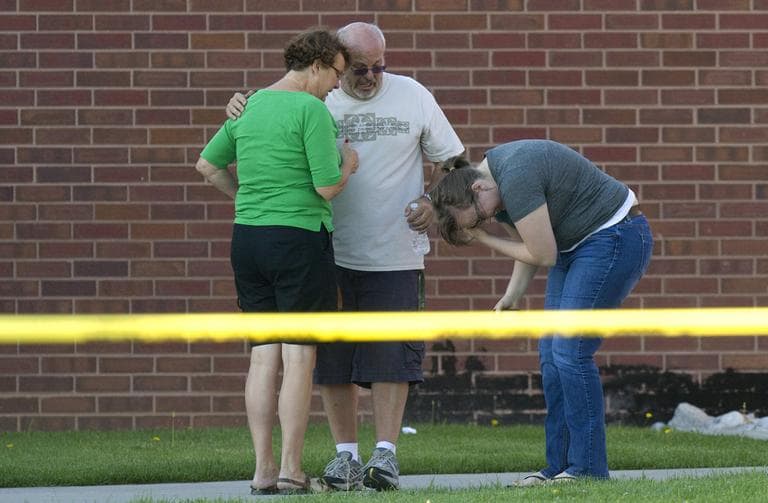 Tom Sullivan, center, stands with family members outside Gateway High School where witness were brought for questioning after a gunman opened fire at the midnight premiere of The Dark Knight Rises Batman movie Friday in Aurora, Colo. (AP)