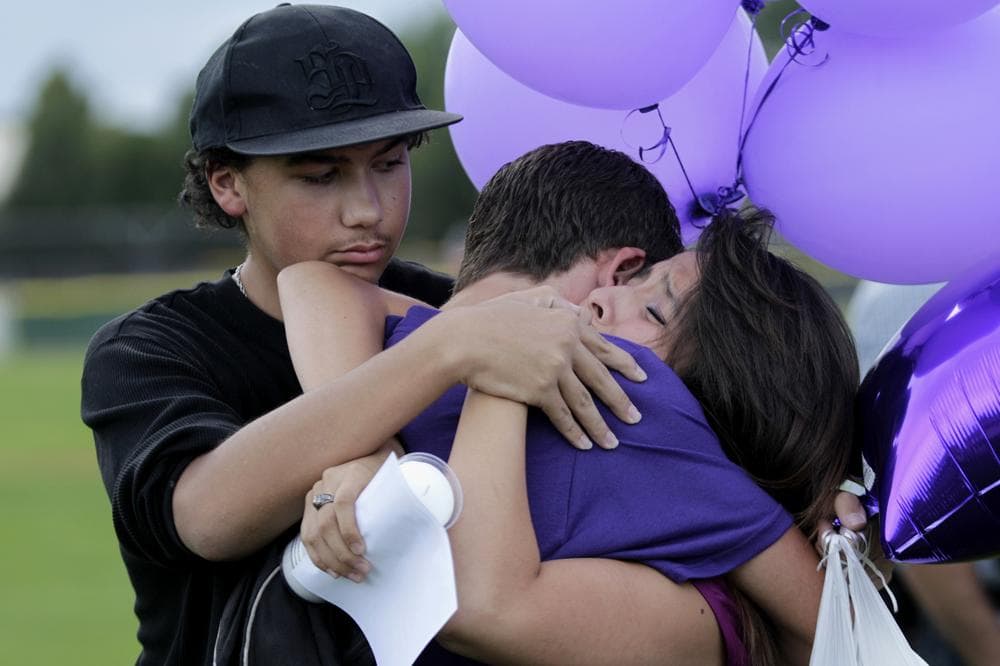 Students comfort each other Saturday, during a vigil at Gateway High School in Aurora, Colo., for AJ Boik, who was a student at the school and who was killed along with 11 others when a gunman opened fire in a movie theater. (AP)