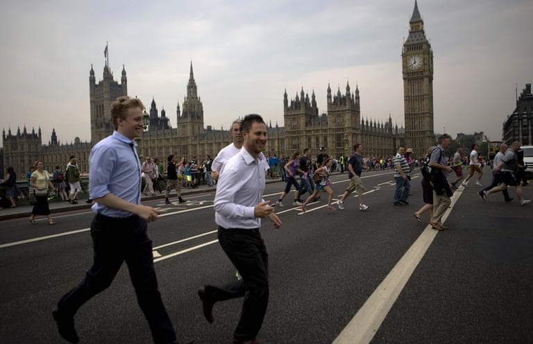 People cross the Westminster bridge to watch the royal barge Gloriana carry the Olympic flame along the river Thames, ahead of the 2012 Summer Olympics, on the final day of the Torch Relay, Friday. (AP)