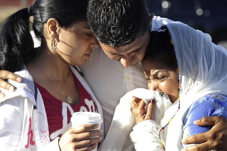 Amardeep Kaleka, son of the president of the Sikh Temple of Wisconsin, center, comforts members of the temple in Oak Creek, Wis., where a gunman killed six people a day earlier, before being shot and killed himself by police. (AP)
