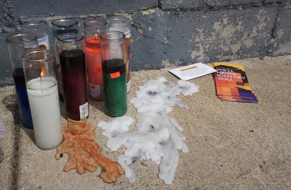 A sidewalk memorial on Harlem Street in Dorchester. The pamphlets are part of the Boston Police Department’s outreach campaign to encourage anonymous reporting of crime. (Aayesha Siddiqui/WBUR)