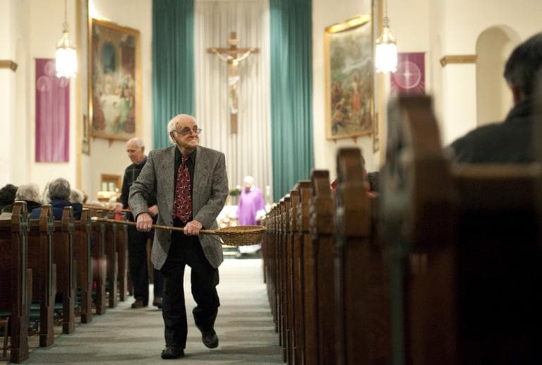 John Alves, of Dartmouth, Mass., uses a basket while taking collection during Mass at St. John the Baptist Church in New Bedford, Mass. in 2009. (AP)