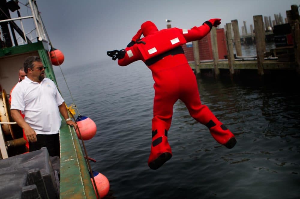 Fred Mattera, a safety trainer, coaches a fisherman in an ‘abandoned ship’ exercise at Point Judith, Rhode Island in August, 2012. (Jesse Costa/WBUR)