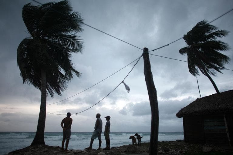 People look out at the beach as Tropical Storm Isaac approaches in Barahona, Dominican Republic, Friday. (AP)