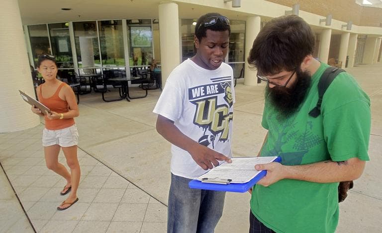 Jordan Allen, center, helps student Casey Eirhstaedt, right, register to vote at the University of Central Florida in Orlando, Fla. (AP/John Raoux)
