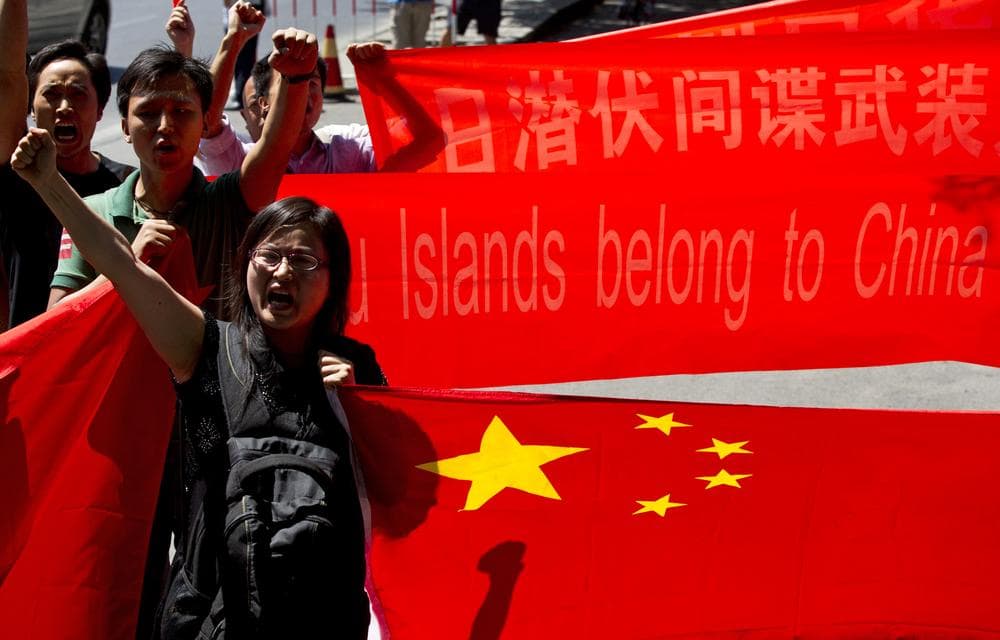 Anti-Japan protesters shout slogans while marching outside Japanese Embassy with Chinese national flags and banners in Beijing, China, Sunday, Aug. 19, 2012. One of the banners reads &quot;Diaoyu Islands belong to China since 1372! &quot; A group of Japanese activists swam ashore and raised flags early Sunday on one of a group of islands at the center of an escalating territorial dispute with China. (AP)