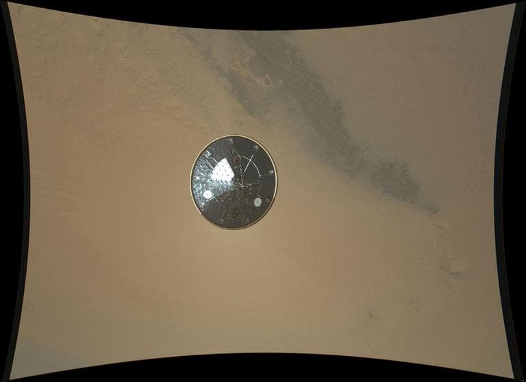 In this image released by NASA on Wednesday, Aug. 8, 2012, an image showing the heat shield of NASA's Curiosity rover, obtained during descent to the surface of Mars. The image was obtained by the Mars Descent Imager instrument known as MARDI and shows the 15-foot diameter heat shield when it was about 50 feet from the spacecraft. (AP/NASA)