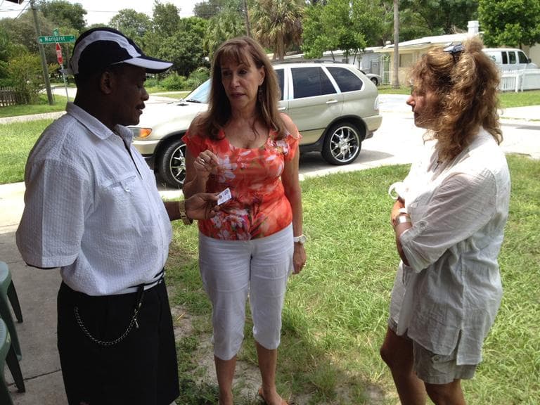 Robin (right) speaks with housing counselor Sylvia Alvarez and Tampa resident Miguel, who said his $200,000 home is now worth less than $70,000. (Chris Ballman/Here & Now)