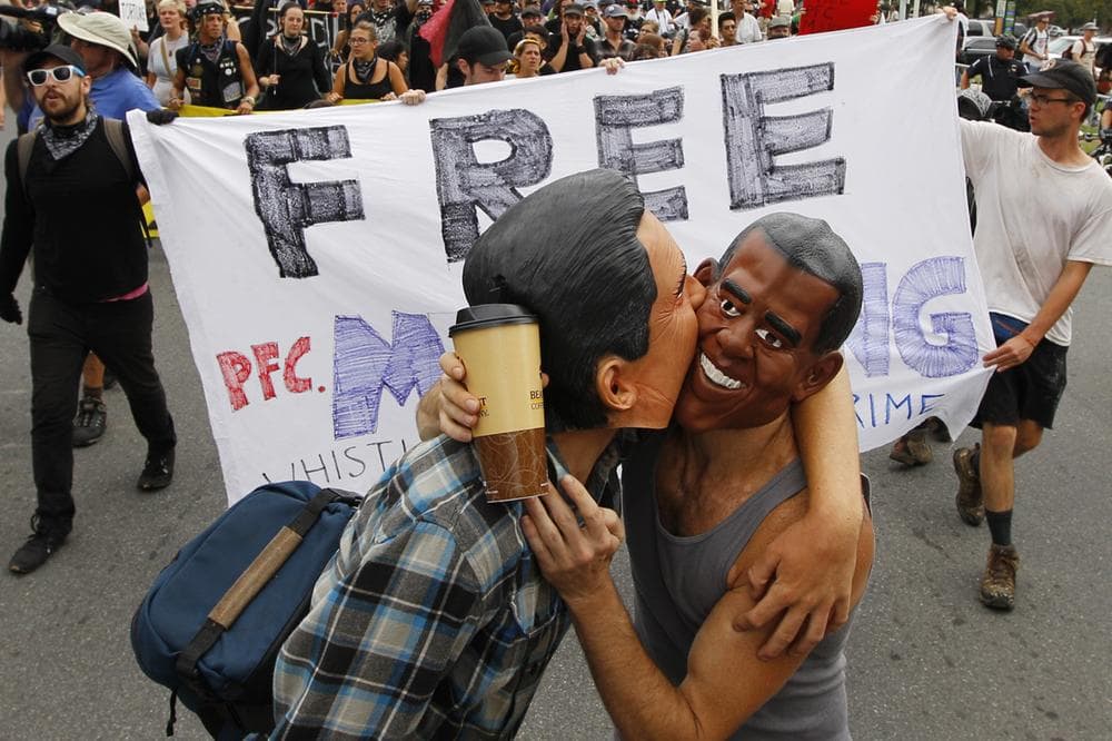 Demonstrators with masks in the likeness of President Barack Obama and Mitt Romney embrace as they move through Charlotte, NC in a protest march, Tuesday, Sept. 4, 2012. (AP Photo)