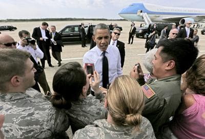 President Barack Obama meets with members of the military on the tarmac at Portsmouth International Airport Friday. (AP)