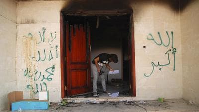 A man looks at documents at the U.S. Consulate in Benghazi, Libya, on Wednesday, after an attack that killed four Americans, including Ambassador Chris Stevens. The graffiti reads, &quot;no God but God,&quot; &quot; God is great,&quot; and &quot;Muhammad is the Prophet.&quot; (AP)
