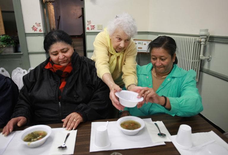 Theresa Martin, a volunteer at the Woodlawn Baptist Church food pantry, delivers soup to Rose Batista, left, and her niece Laura Batista during a service at the food pantry called Bread and Broth for Lent, in Pawtucket in 2009. (AP)