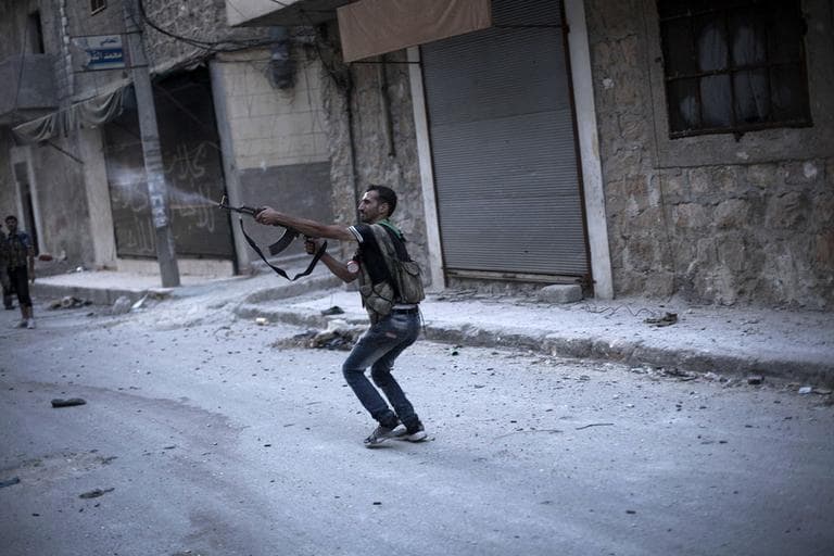 A Free Syrian Army fighter fires his weapon against Syrian Army positions in the Amariya district in Aleppo, Syria. (AP)
