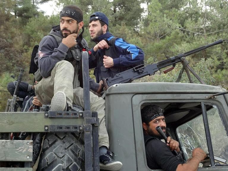 Free Syrian Army fighters sit on top of a military truck that was captured from the Syrian Army in the village off Khirbet al-Jouz, in the northern province of Idlib, Syria. (AP/Edlib News Network)