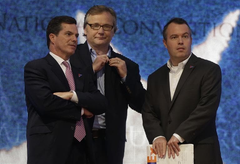 Advisers Peter Flaherty, left, Eric Fehrnstrom center, and campaign manager Matt Rhoades stand on stage as Republican presidential candidate Mitt Romney checks the podium at the Republican National Convention in Tampa, Fla., in August 2012. (AP/Charles Dharapak)