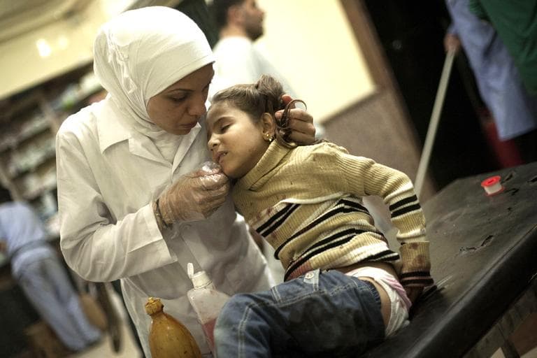 A Syrian nurse treats a girl wounded by Syrian Army artillery shelling at Dar El Shifa hospital in Aleppo, Syria, on Wednesday. (AP/Manu Brabo)