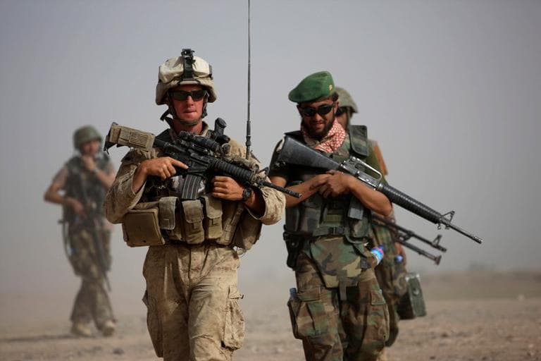 A U.S. Marine squad leader, left, walks with an Afghan National Army lieutenant during a joint patrol in Helmand province, southern Afghanistan. (AP/Brennan Linsley)