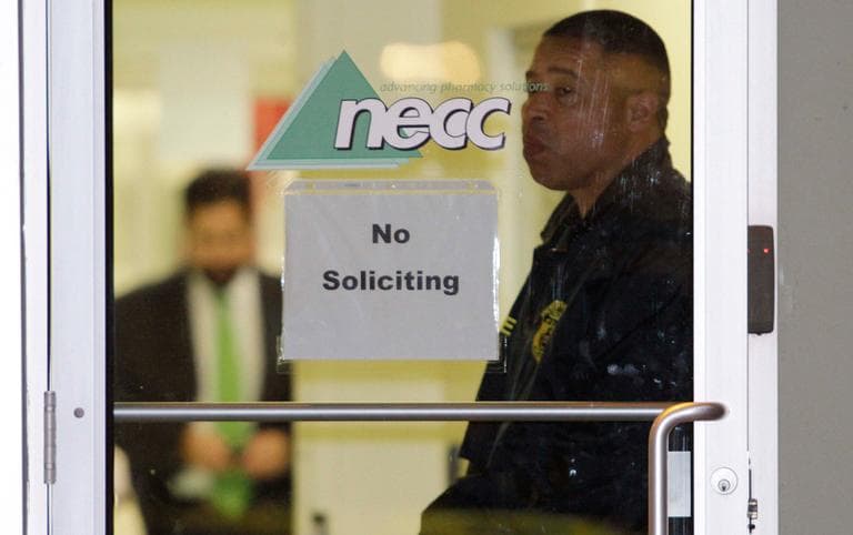 A Food and Drug Administration agent stands at the doorway of New England Compounding Center in Framingham Tuesday as investigators work inside. (Bill Sikes/AP)