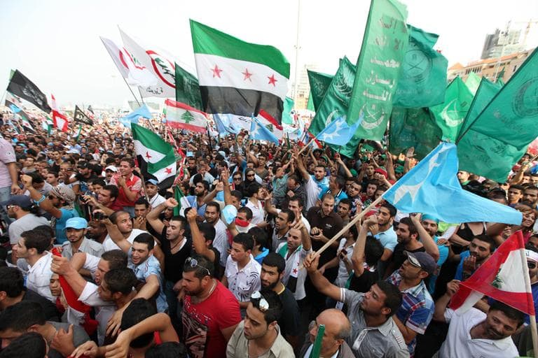 Lebanese protesters wave Syrian revolutionary flags, national flags and Islamic flags as they gather in Martyrs' Square at funeral for the country's intelligence chief, Brig. Gen. Wissam al-Hassan in Beirut, Lebanon, Sunday, Oct. 21, 2012. (Bilal Hussein/AP)