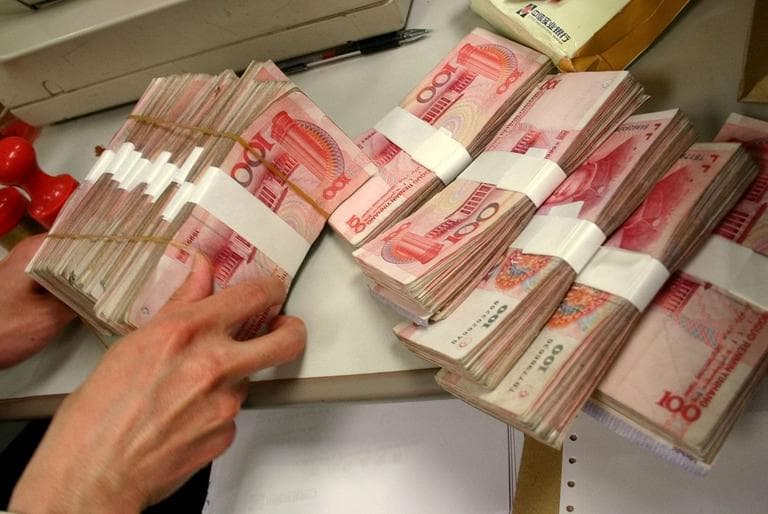 A teller handles Chinese Yuan in a bank in Beijing. U.S. manufacturers and other critics accuse China of holding its currency artificially low, causing the trade deficit to soar, and the loss of American factory jobs. (AP)