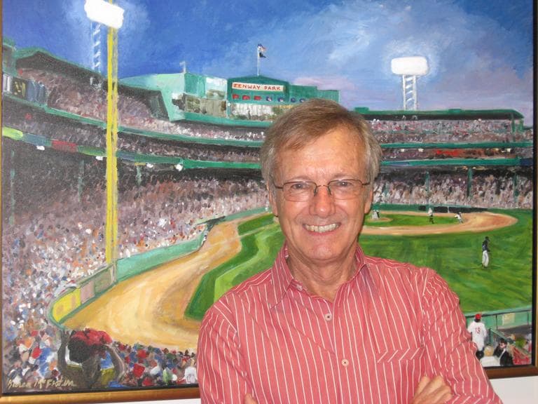 Tony Wheeler, posing in front of a painting of Boston's Fenway Park by Karen McFeaters, at WBUR. (Here & Now/Lynn Menegon)